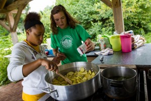 Farm-based Educator assists Crew Member in preparing sauteed summer squash harvested from the YCAP field.